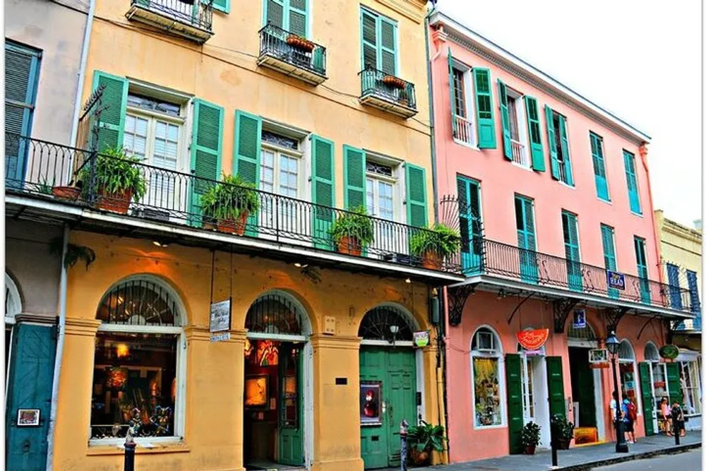 The image shows a vibrant street view with colorful buildings featuring architectural details like balconies and shutters indicative of a historical and possibly European or European-influenced setting