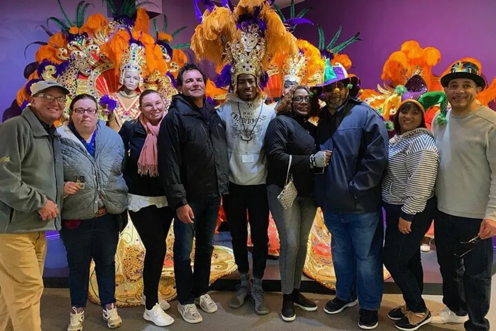 A group of people is posing for a photo in front of colorful and elaborate carnival costumes