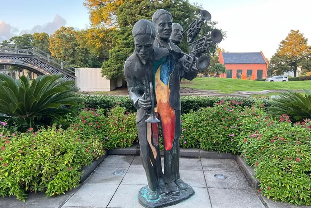 A colorful statue of two jazz musicians one holding a trumpet and the other a saxophone stands amidst verdant shrubbery in an outdoor setting