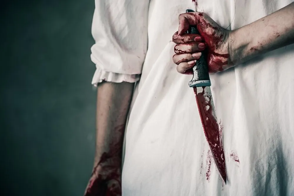 The image depicts a person in a white garment holding a blood-stained knife with bloodied hands against a dark background