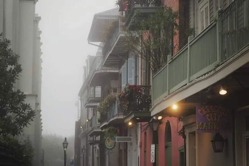 The photo depicts a foggy street scene with traditional balconied buildings evocative of the French Quarter in New Orleans