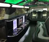 The image shows the luxurious and spacious interior of a limousine complete with mood lighting a bar area and plush seating