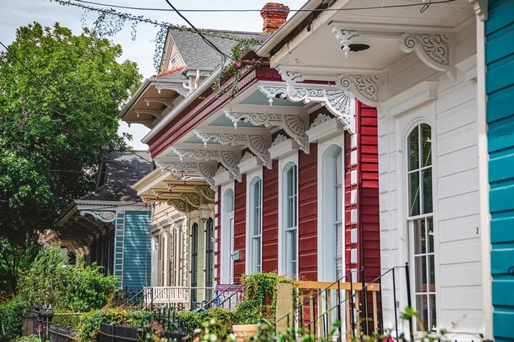 A row of colorful houses with ornate Victorian-style trim and welcoming porches lining a sunny street