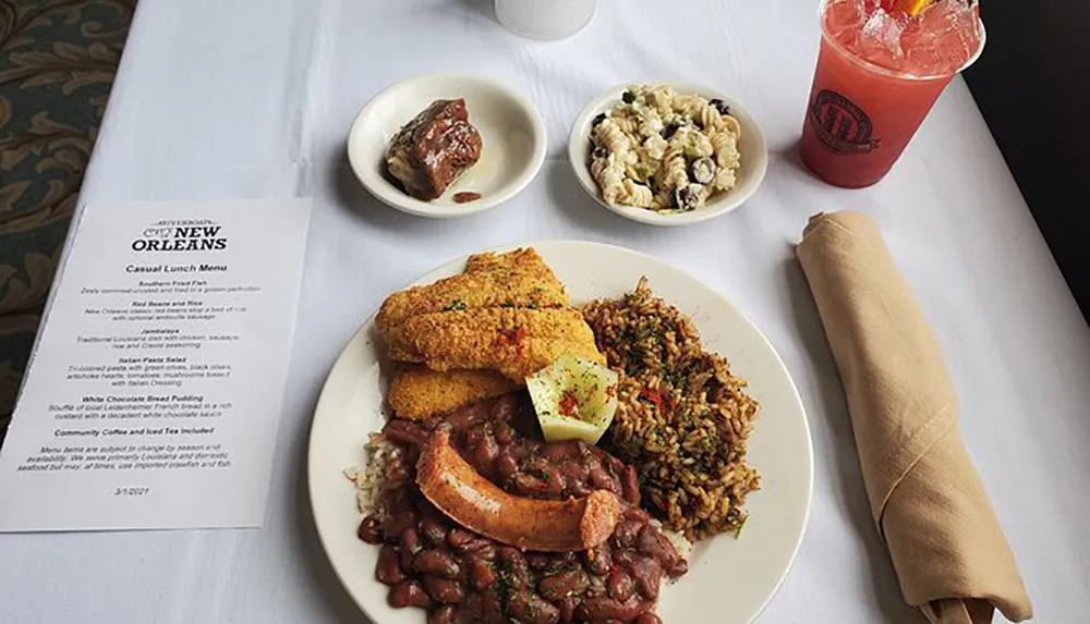 The image displays a table with a Southern-style meal consisting of fried fish rice beans pasta salad a small desert a beverage and a menu titled New Orleans Casual Lunch Menu