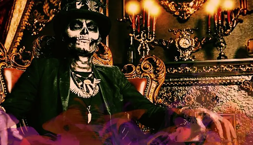 A person with skull face makeup is seated in an ornate chair with purple smoke around evoking a mystical or Gothic atmosphere