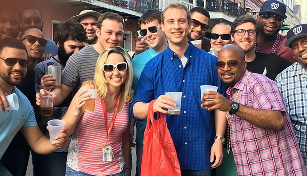 A group of smiling people are posing for a photo while holding drinks creating a sociable atmosphere