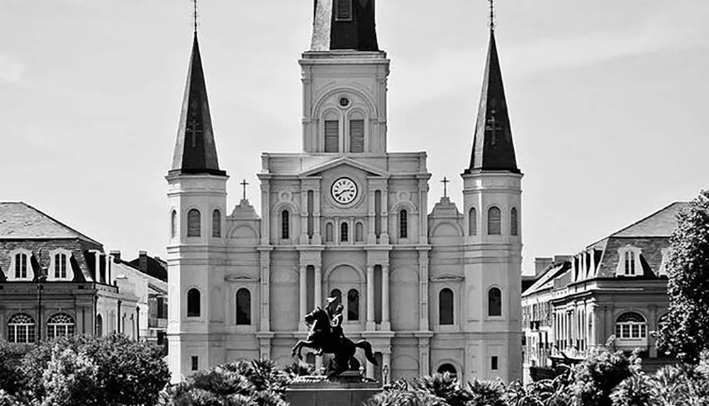 The image shows a black and white photograph of the iconic St Louis Cathedral and the statue of Andrew Jackson at Jackson Square New Orleans