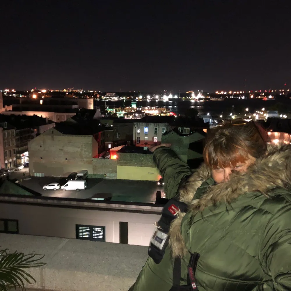 A person is looking out over a cityscape at night from a high vantage point