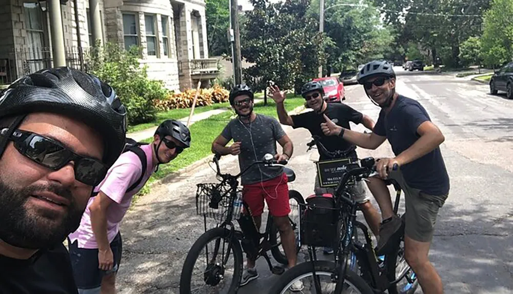 A group of cheerful people on bikes are posing for a selfie on a sunny residential street