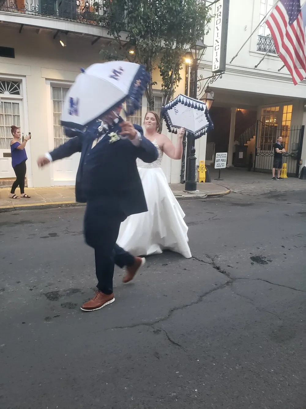A joyful bride and groom are participating in a lively second line parade a traditional New Orleans celebratory procession with umbrellas in hand
