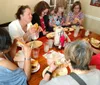 A group of people is enjoying what appears to be a casual meal together at a restaurant with several of them eating sandwiches and all of them engaged in conversation or focused on their food