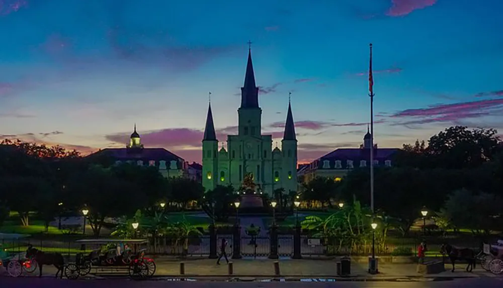The image captures a picturesque sunset view of Jackson Square with St Louis Cathedral in New Orleans featuring a horse-drawn carriage in the foreground