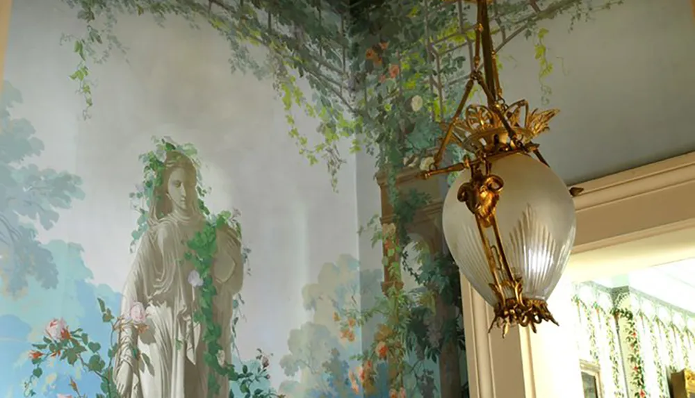 The image shows an elegant interior with a mural of a classical statue surrounded by foliage and a decorative golden chandelier featuring a large frosted glass light