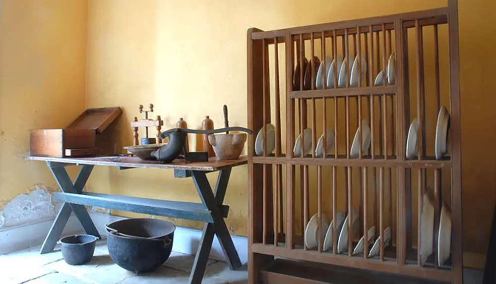 The image shows a rustic shoemakers workshop with various tools and wooden shoe lasts organized on a rack and table