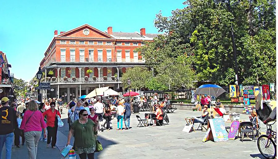 The image depicts a vibrant street scene with people wandering among outdoor artists' displays and colonial-style buildings in what appears to be a bustling city square.