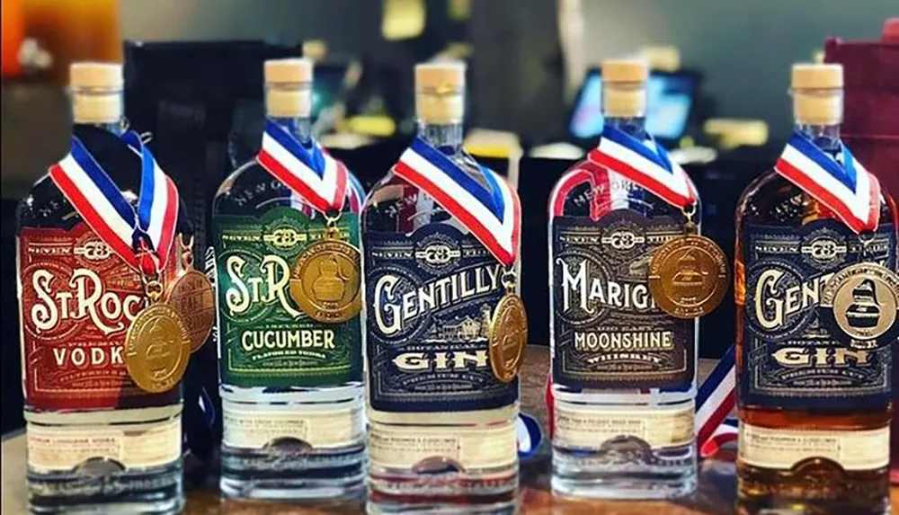 A collection of award-winning bottles of vodka cucumber-flavored spirit gin moonshine and more gin each adorned with a medal are lined up for display