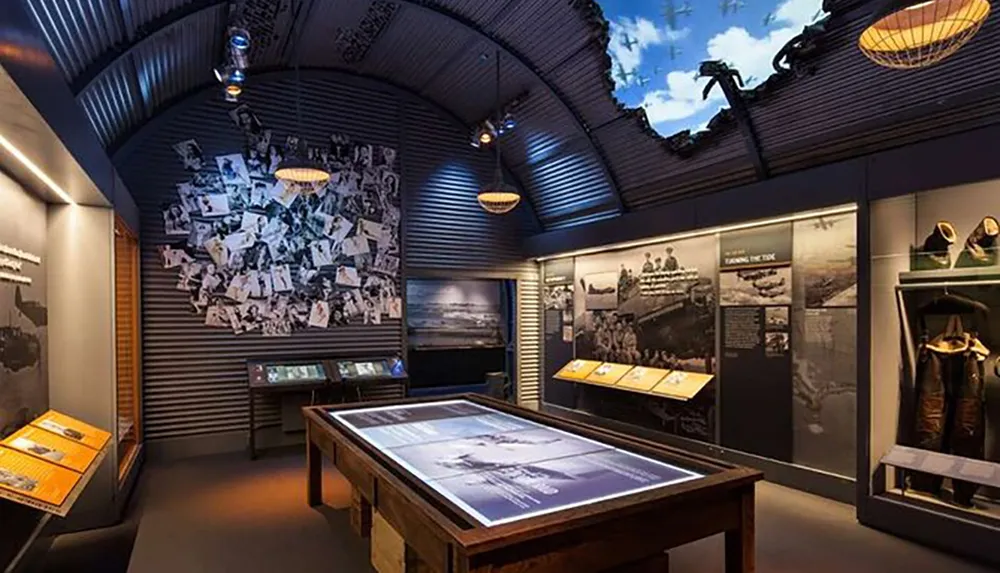 The image depicts an interior view of a museum exhibit displaying an array of historical photographs artifacts and informational panels to educate visitors about a particular aspect of history