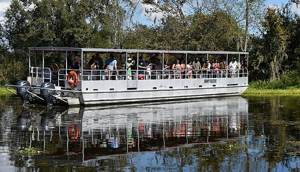 Tourists enjoy a guided boat tour on a calm river amidst lush greenery
