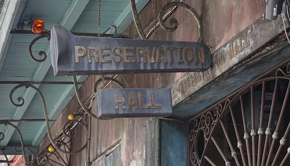 The image displays a weathered sign for Preservation Hall known for its traditional New Orleans jazz performances