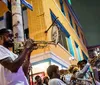 A group of musicians is performing on a vibrant street corner at night adding a lively ambiance to the urban setting