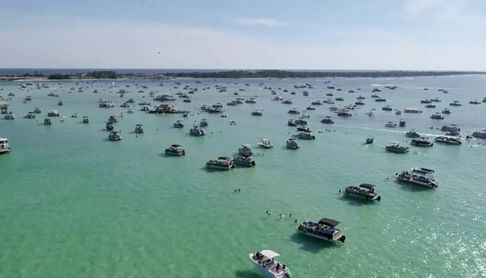 The image shows numerous boats scattered across a calm turquoise sea suggesting a busy day on the water for leisure or a special marine event