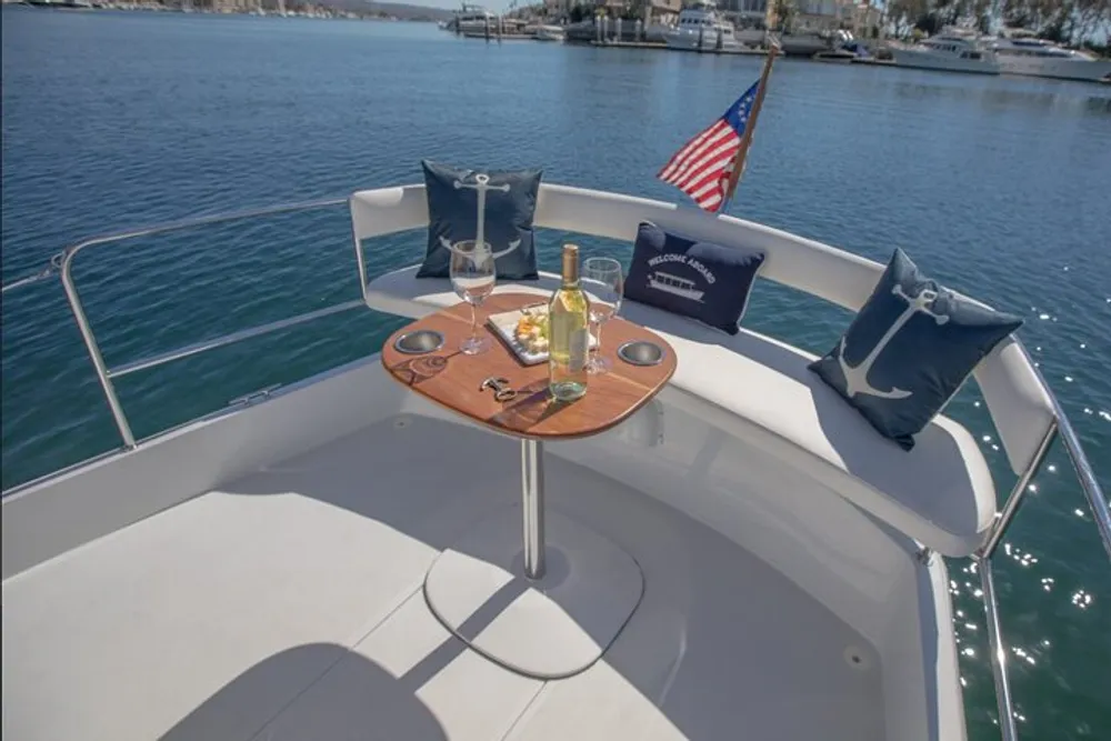 A luxury boat is set up with a table holding wine and snacks ready for a relaxing time on the water with an American flag displayed at the stern