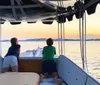 Three women are sharing a joyful moment on a boat with a beautiful sunset in the background