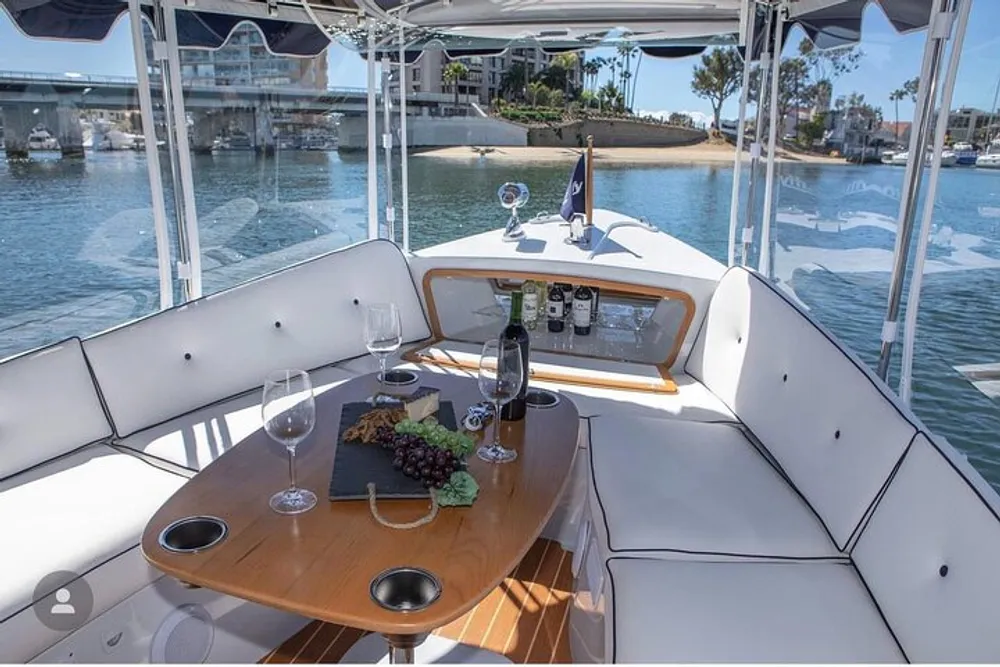 A luxury boat is set up with a wine and cheese platter ready for a relaxing outing on the water with a view of other boats and waterfront properties