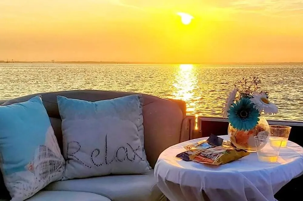 A cozy waterfront seating area with a Relax pillow snacks and a sunset view