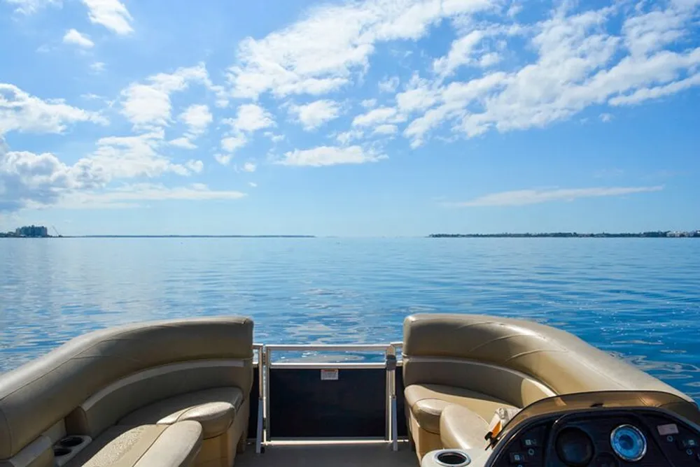 The image shows the view from the helm of a boat looking out over calm blue waters and a clear sky with no people in sight