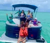 A group of people likely a family are posing for a photo on a pontoon boat enjoying a day on the water under an overcast sky