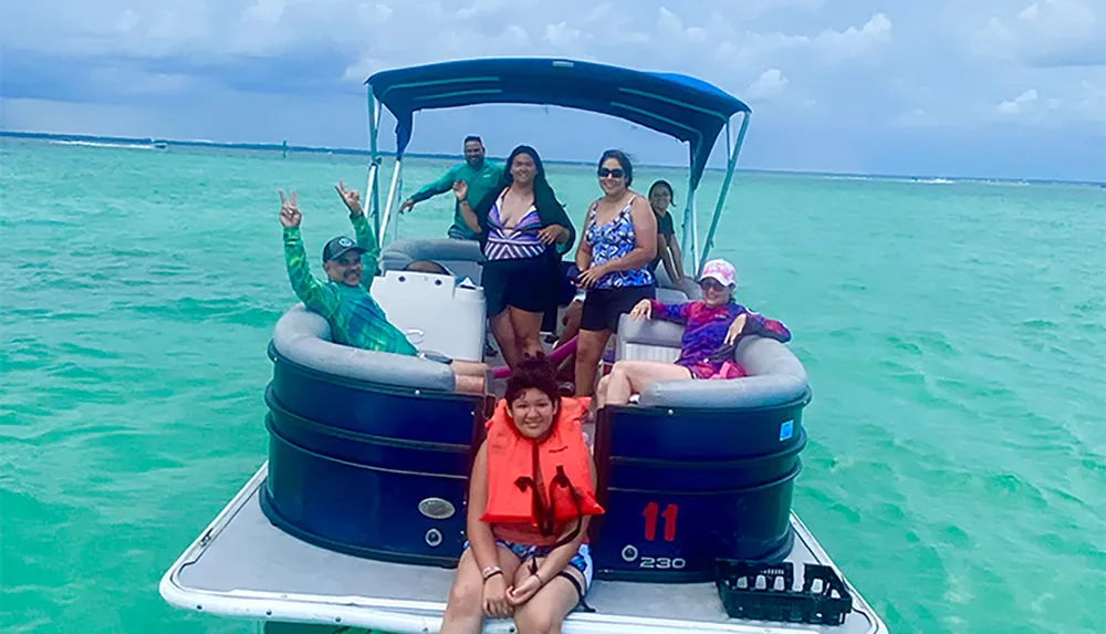 A group of people is enjoying a boat ride on a sunny day with clear turquoise waters in the background