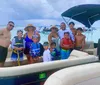 A group of people likely a family are posing for a photo on a pontoon boat enjoying a day on the water under an overcast sky