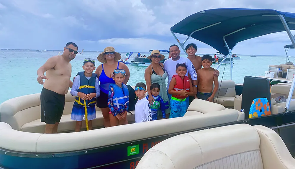 A group of people likely a family are posing for a photo on a pontoon boat enjoying a day on the water under an overcast sky