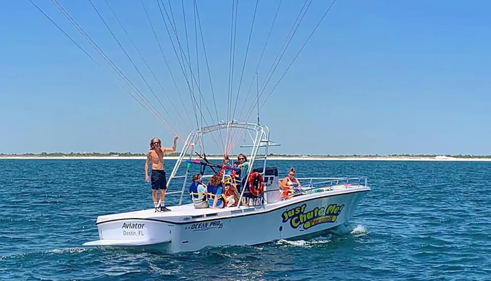 A group of individuals are preparing for parasailing on a boat against a clear blue sky and sea