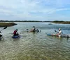 A person is paddling a transparent kayak over clear water offering a view of the underwater environment