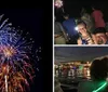 A girl smiles for the camera with a man beside her while other people watch fireworks at night