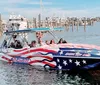 A group of people enjoy a ride on a speedboat adorned with an American flag design in a marina