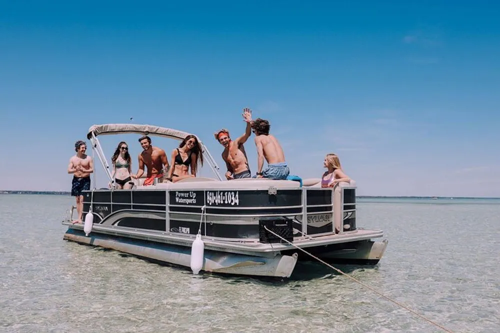 A group of young people are enjoying themselves on a pontoon boat on a clear day with calm waters