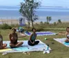 Two people are lying on yoga mats in a relaxation pose seemingly engaged in an outdoor yoga practice