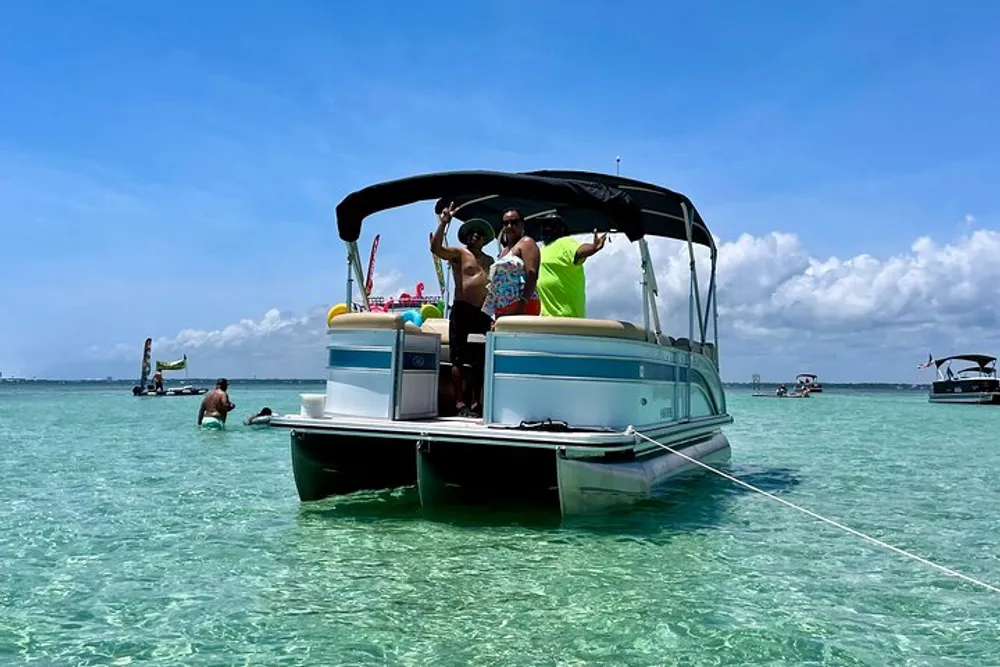 A group of people is enjoying a sunny day on a pontoon boat in clear turquoise waters