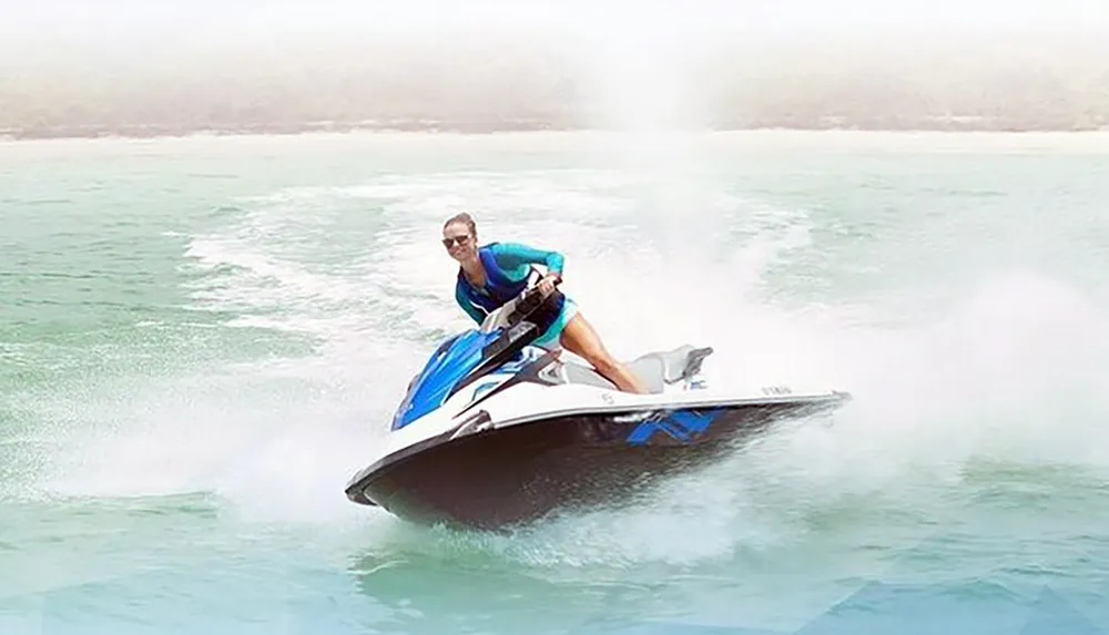 A person is riding a jet ski at high speed on what appears to be a misty water surface
