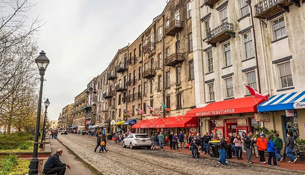 The image shows a bustling street scene with pedestrians shops old buildings and a cobbled sidewalk reflecting a vibrant urban atmosphere
