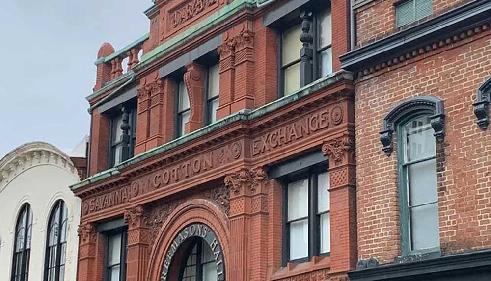 The image shows the detailed brick faade of the Savannah Cotton Exchange building an architectural landmark