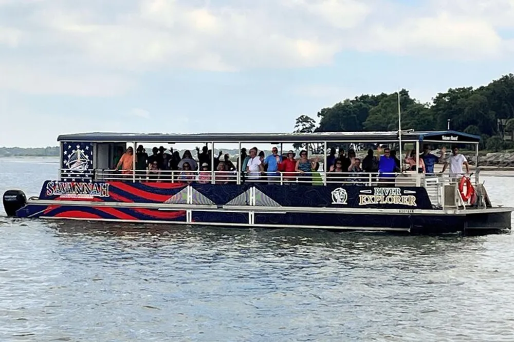 A group of passengers is enjoying a ride on a sightseeing boat named Savannah River Explorer on a calm body of water