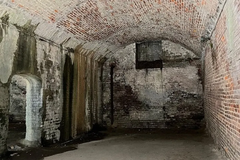 The image displays an old dimly-lit brick tunnel with arched ceilings showing signs of decay and moisture damage