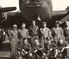 A group of nine uniformed military personnel poses in front of a twin-engine bomber aircraft likely from the World War II era