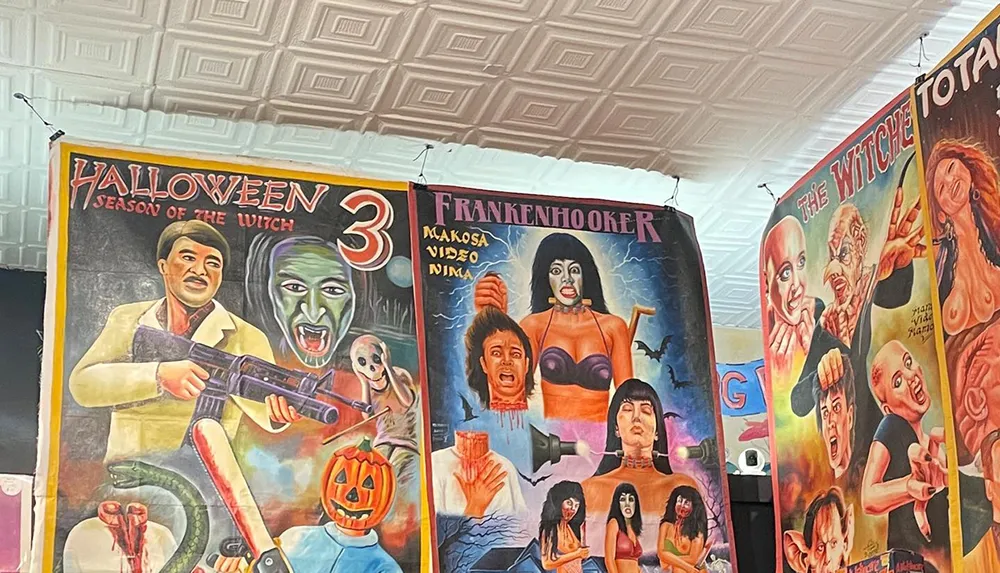 The image shows three vibrant hand-painted movie posters featuring horror films displaying a distinct style often seen in Ghanaian mobile cinema