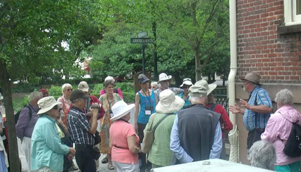 A group of tourists gather around a guide for an outdoor walking tour