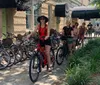 A group of people are smiling and posing with their bicycles on a sunny day possibly during a group ride or a social event